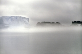 Mlha na moři před stanicí. Z ní trčí ledovec, který na cestě oceánem uvízl na mělčině.